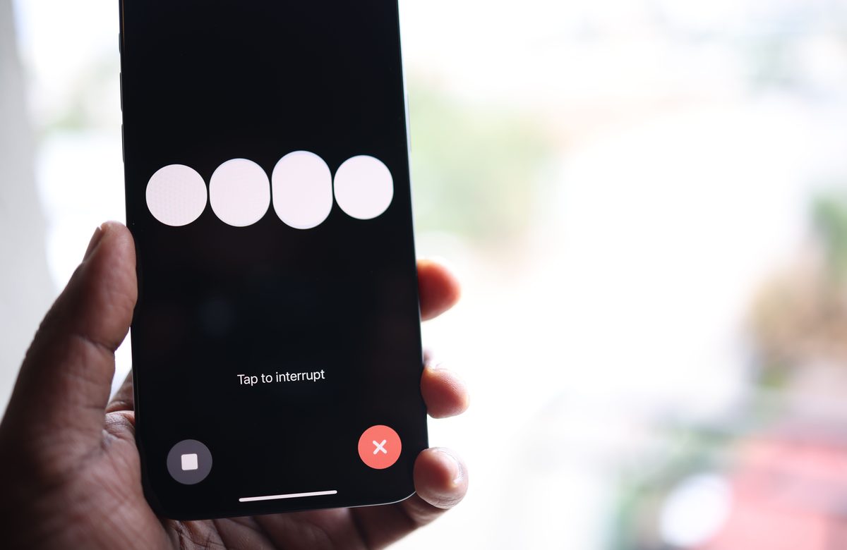 Téléphone tenu à la main, affichant un assistant vocal en pleine conversation
